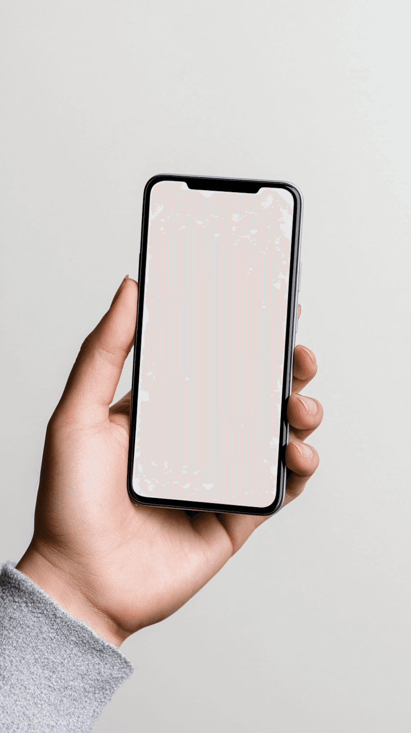 Dorë që mban një telefon me ekran të bardhë mbi sfond gri